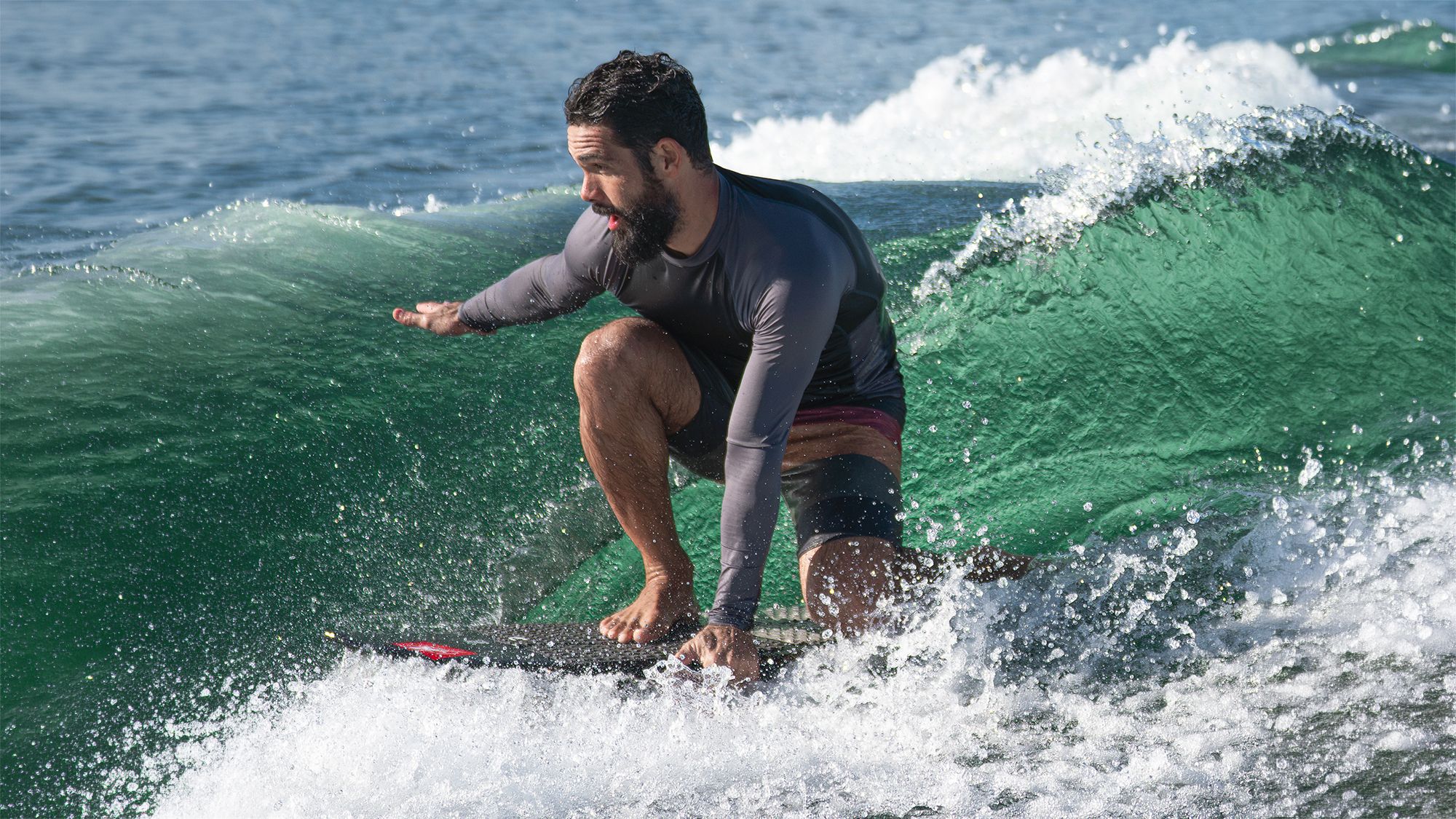 Surfista fazendo carve na onda verde