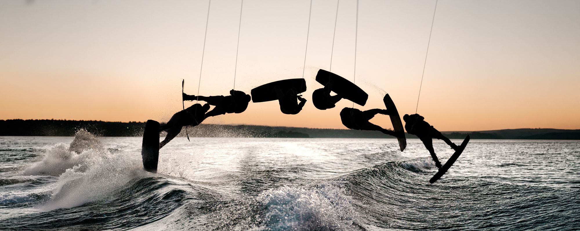 Sequência de manobra de wakeboard em silhueta no pôr do sol do Lago Paranoá